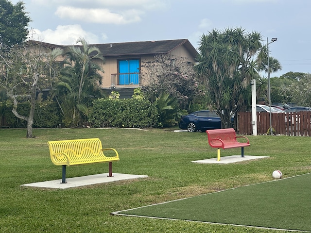 surrounding community with a lawn and fence