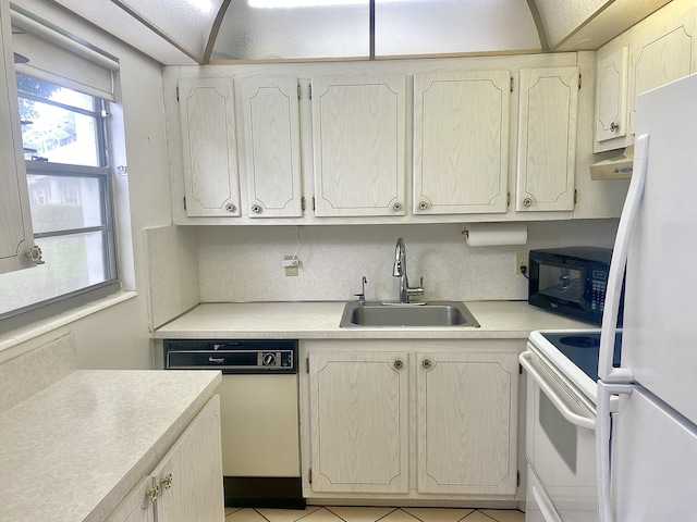 kitchen with white appliances, light countertops, a sink, and backsplash