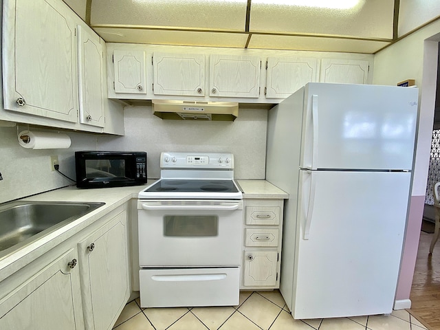 kitchen featuring white appliances, light tile patterned floors, light countertops, under cabinet range hood, and a sink