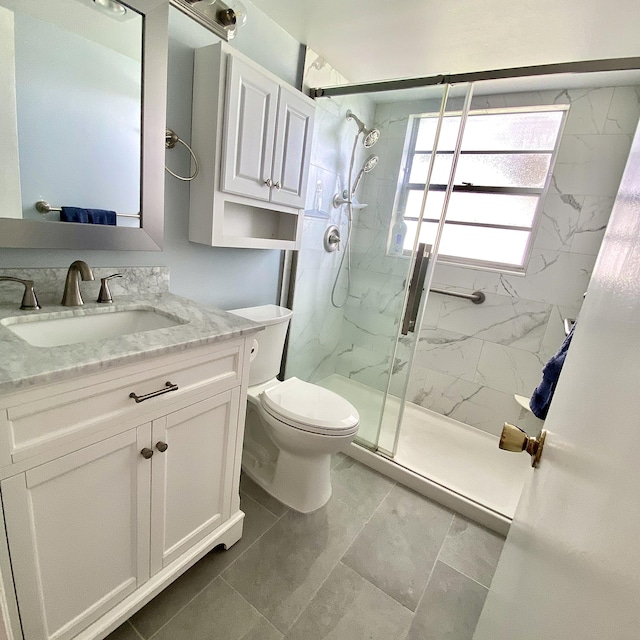 full bath featuring toilet, a marble finish shower, and vanity