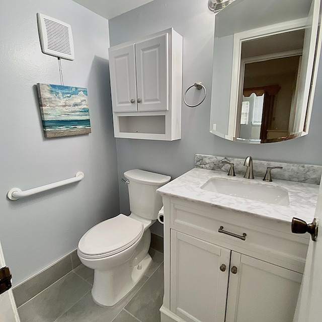 bathroom featuring toilet, tile patterned flooring, baseboards, and vanity