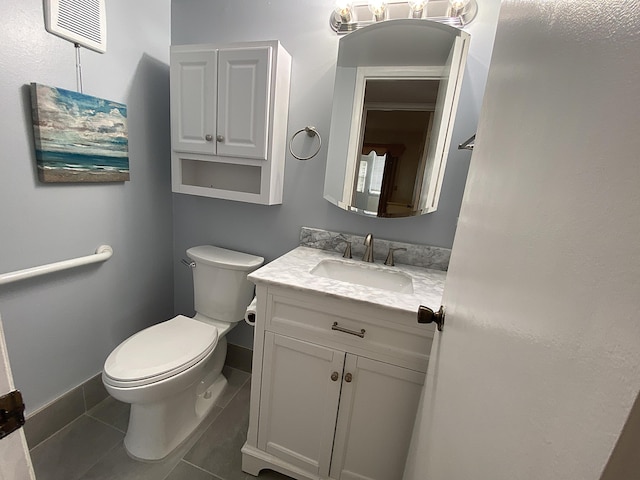 bathroom with baseboards, vanity, toilet, and tile patterned floors