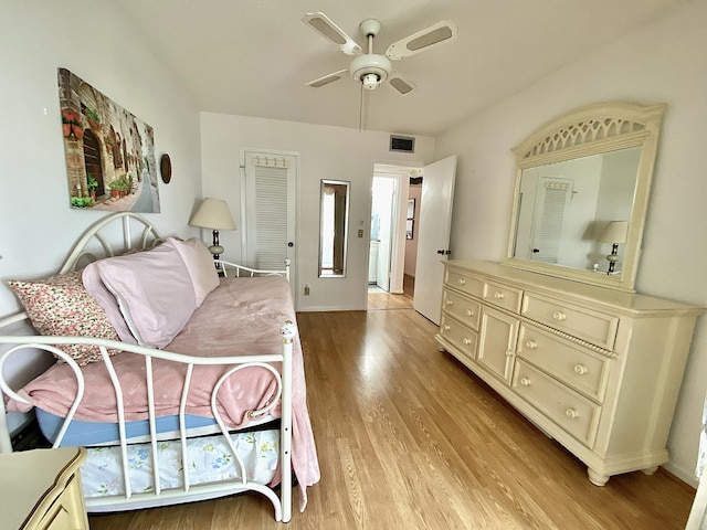 bedroom with ceiling fan, light wood finished floors, and visible vents