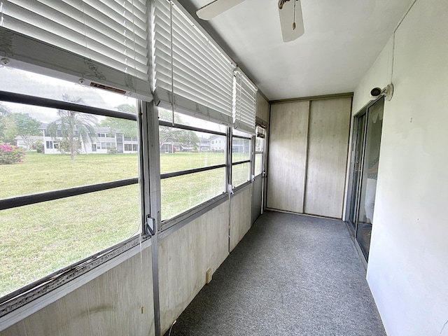 unfurnished sunroom featuring ceiling fan