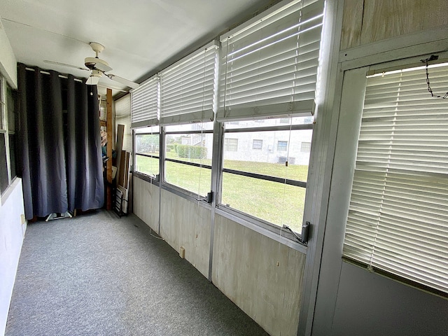 unfurnished sunroom featuring ceiling fan