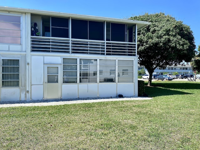 view of home's exterior with a lawn and a sunroom