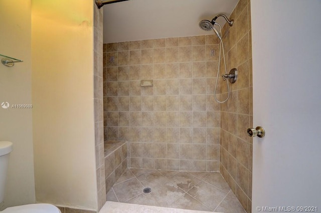 bathroom with tiled shower and toilet