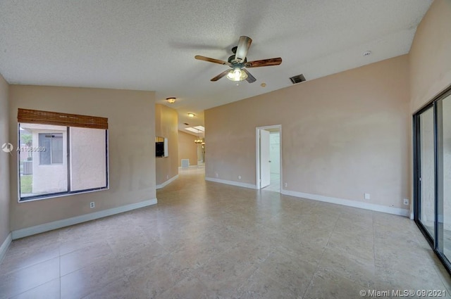 unfurnished room with visible vents, a textured ceiling, baseboards, and ceiling fan