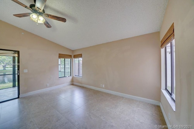 unfurnished room featuring baseboards, a textured ceiling, and vaulted ceiling