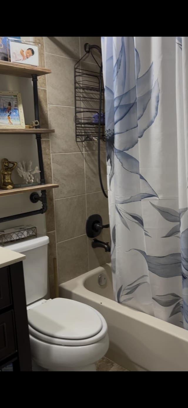 bathroom with toilet, shower / bath combo, and vanity