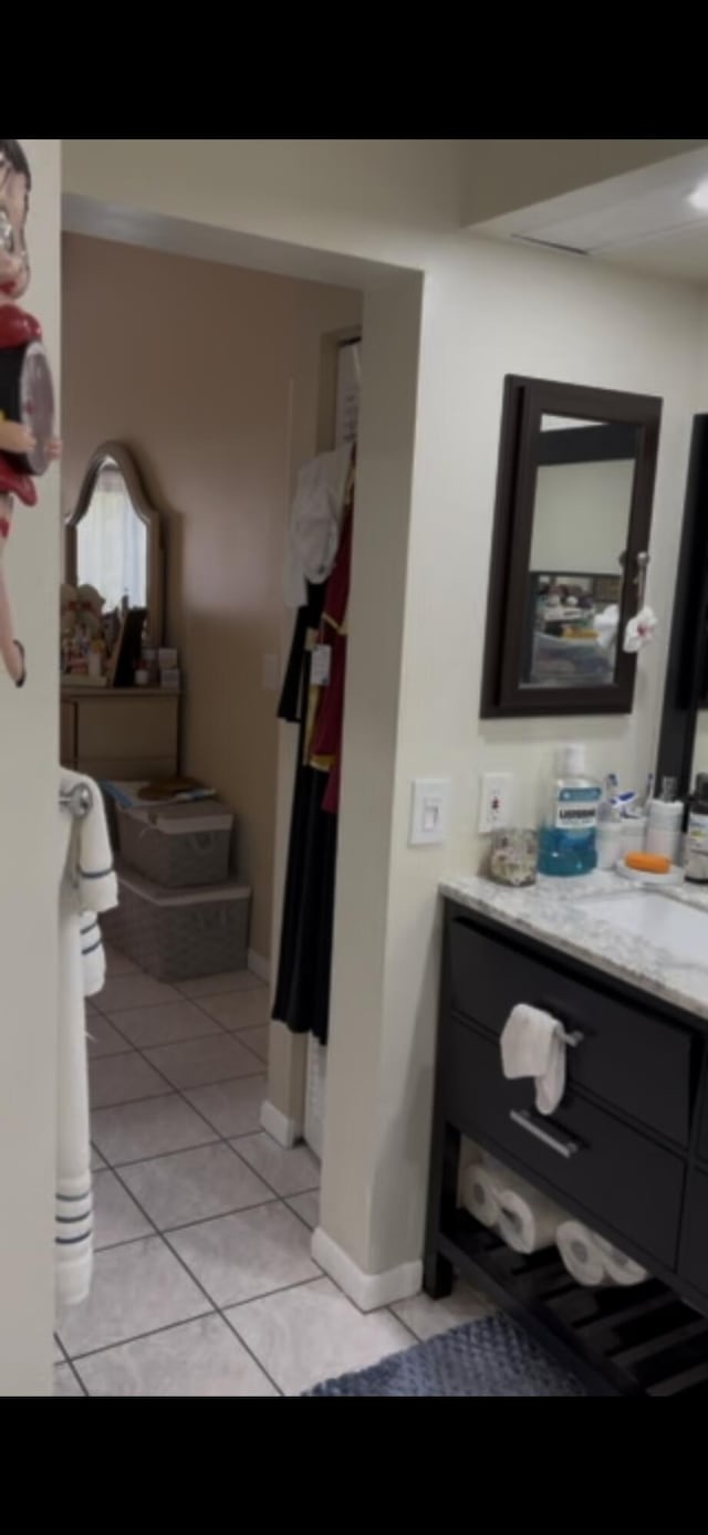 bathroom with tile patterned floors, baseboards, and vanity