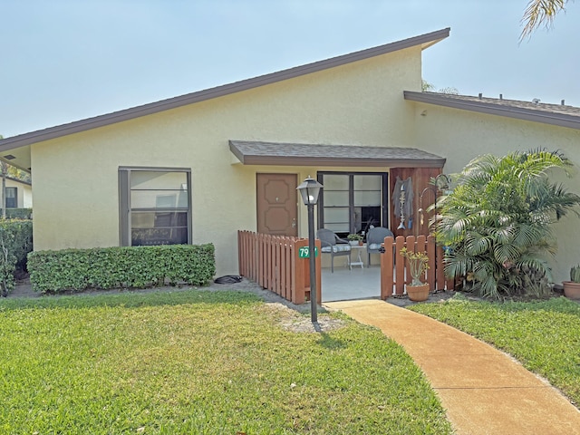 view of front of property with stucco siding and a front lawn