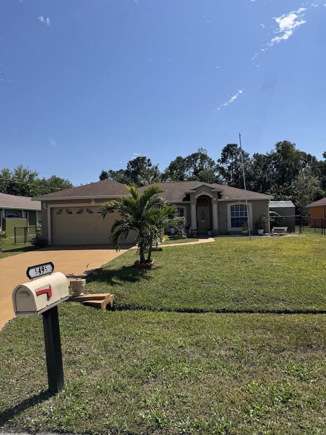 view of front of home with a garage, fence, and a front yard