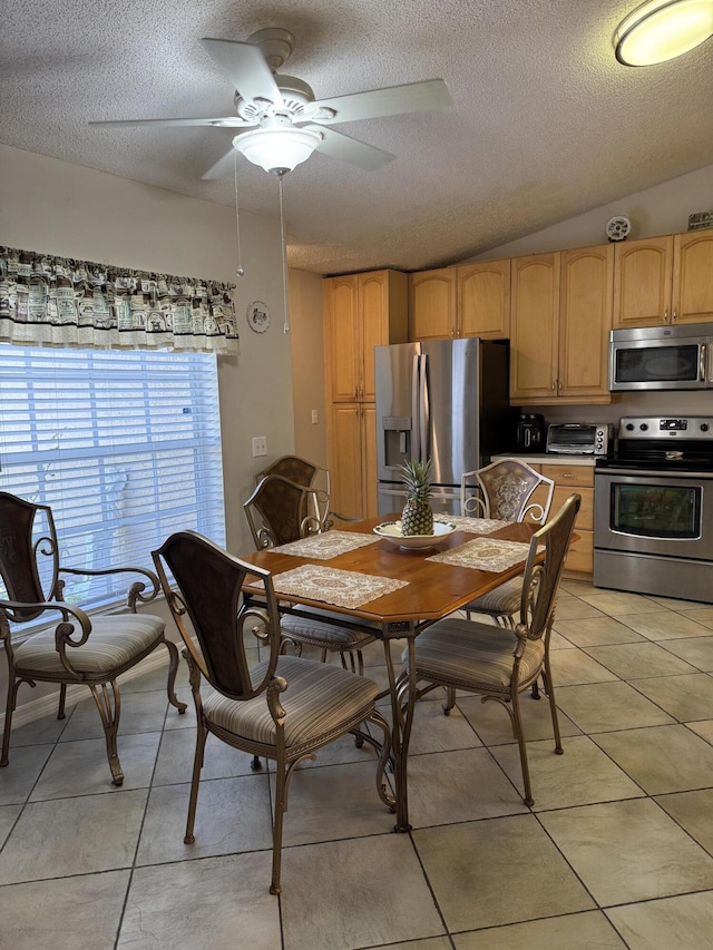 dining room featuring a ceiling fan, a toaster, a textured ceiling, and light tile patterned floors