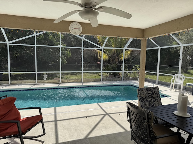 pool with a ceiling fan, glass enclosure, and a patio