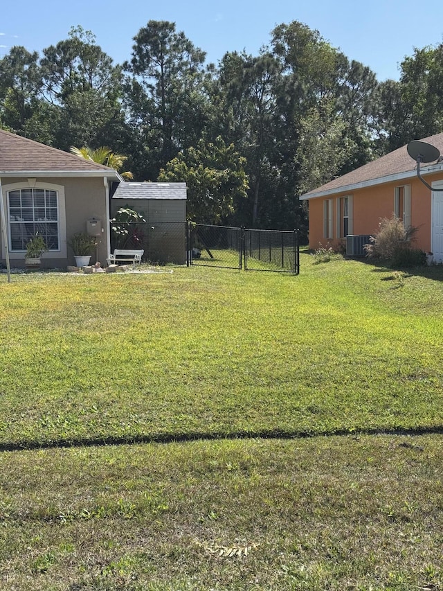 view of yard featuring a gate, fence, and cooling unit