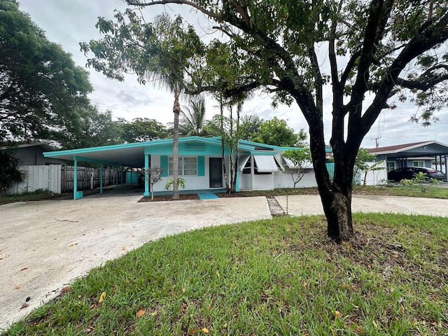 manufactured / mobile home featuring driveway, a carport, and fence