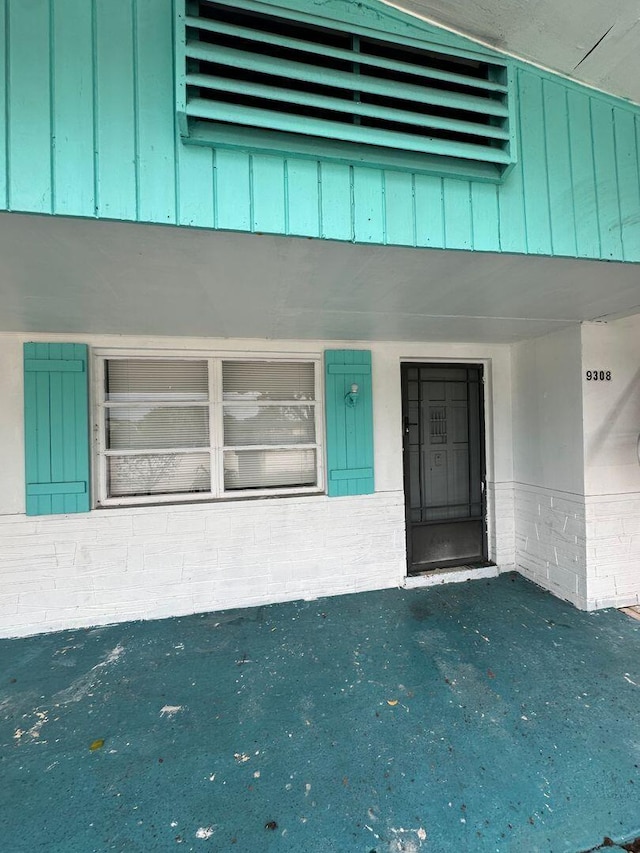 view of exterior entry featuring board and batten siding