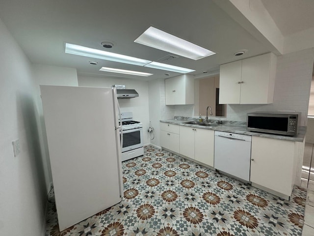 kitchen featuring white appliances, exhaust hood, a sink, white cabinets, and light floors