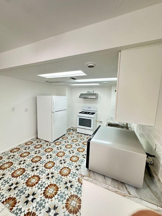 kitchen with white appliances, baseboards, ventilation hood, and white cabinets