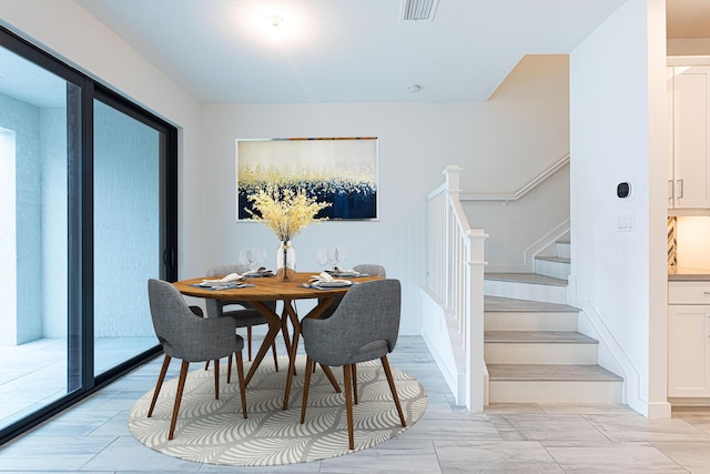 dining space with visible vents and stairs