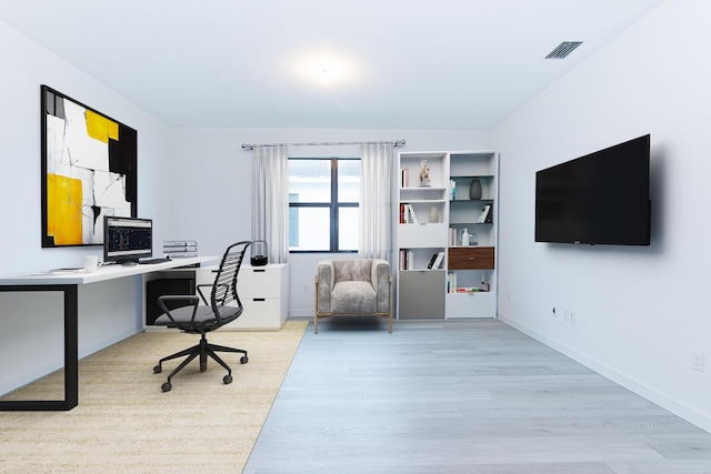 office space with wood finished floors, visible vents, and baseboards