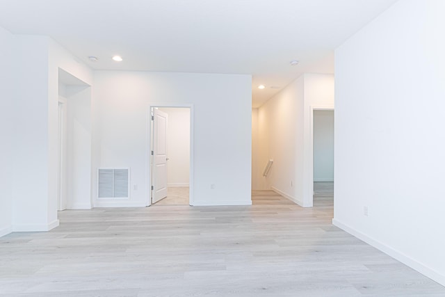 spare room featuring light wood-style floors, baseboards, visible vents, and recessed lighting