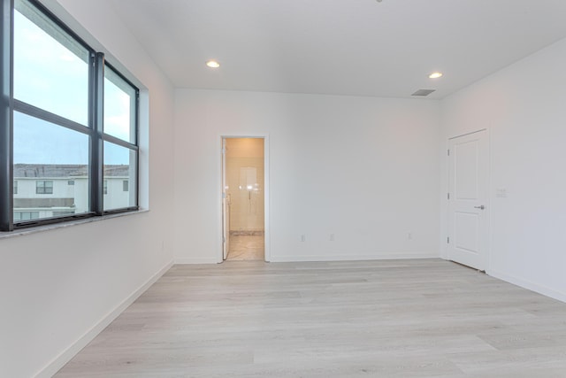 unfurnished room with visible vents, recessed lighting, light wood-style flooring, and baseboards