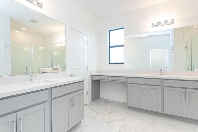 full bath with a stall shower, marble finish floor, and a sink