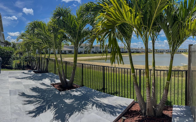 exterior space featuring a yard, a patio, a water view, and a fenced backyard