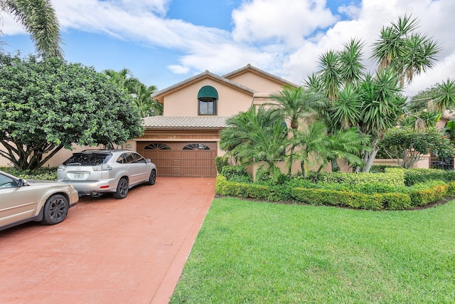 view of front of house featuring stucco siding, a front lawn, and driveway