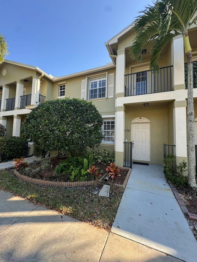 entrance to property with a balcony and stucco siding