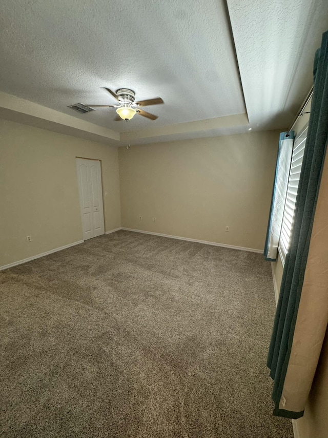 unfurnished bedroom featuring visible vents, a textured ceiling, baseboards, and carpet floors