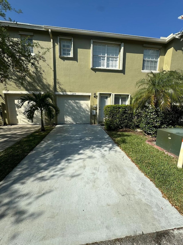 view of front of property featuring stucco siding, concrete driveway, and an attached garage