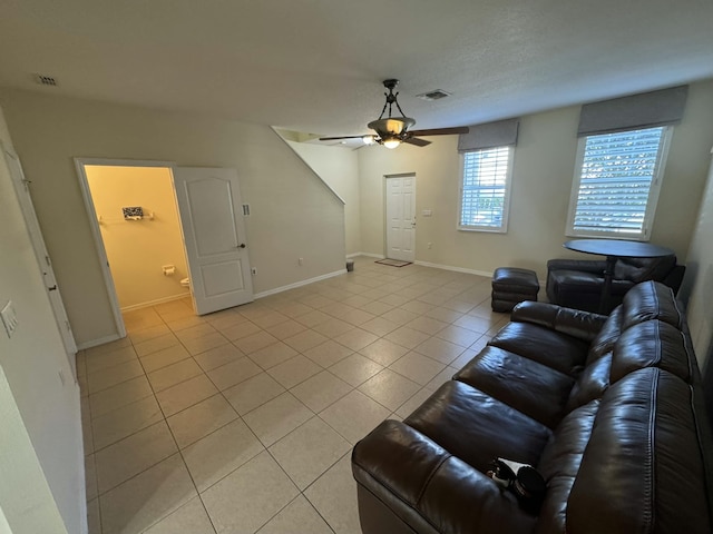 living room with visible vents, baseboards, light tile patterned flooring, and a ceiling fan