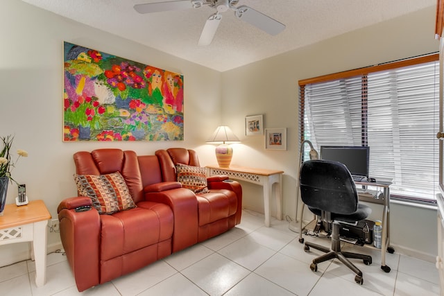 home office with light tile patterned floors, baseboards, a ceiling fan, and a textured ceiling