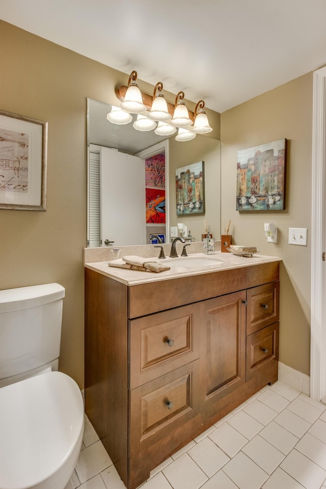 bathroom featuring baseboards, vanity, toilet, and tile patterned floors