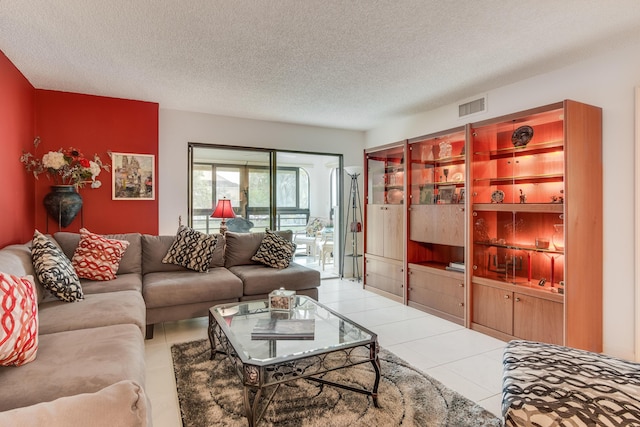 living area featuring a textured ceiling, visible vents, and tile patterned floors