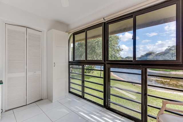 entryway featuring a water view and light tile patterned floors