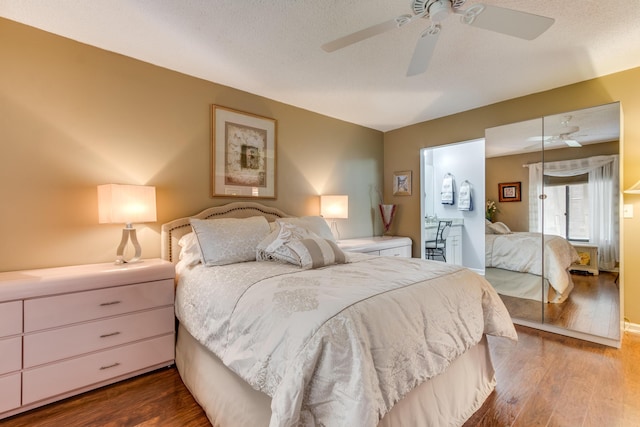 bedroom with a textured ceiling, wood finished floors, and a ceiling fan