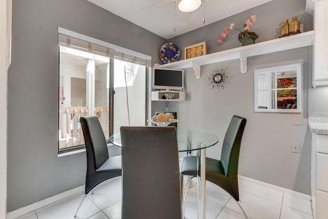 dining room with light tile patterned floors, baseboards, and a ceiling fan