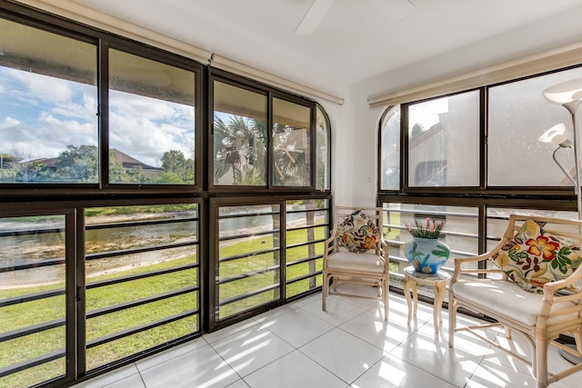 sunroom / solarium with a water view and ceiling fan