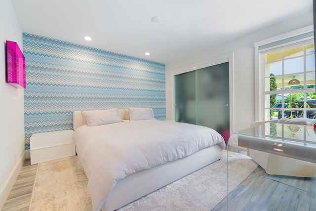 bedroom featuring baseboards, wallpapered walls, recessed lighting, a closet, and an accent wall