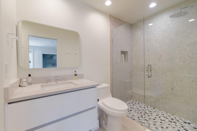 bathroom with vanity, a shower stall, toilet, and recessed lighting