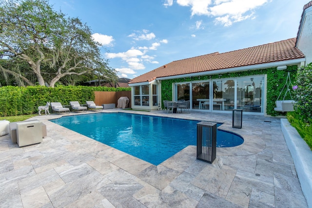 view of swimming pool featuring a patio area, a fenced in pool, and fence