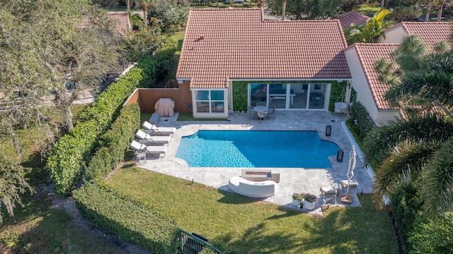 pool featuring a patio and a lawn