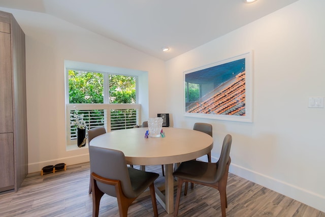 dining room with recessed lighting, baseboards, lofted ceiling, and light wood finished floors