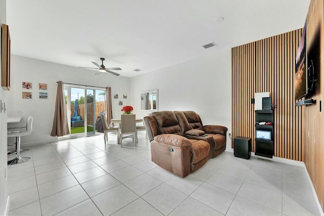 living room with light tile patterned floors, visible vents, baseboards, and ceiling fan