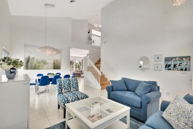 living room with light tile patterned flooring, visible vents, stairs, and a high ceiling