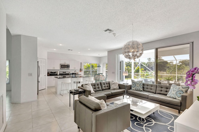 living room with visible vents, light tile patterned floors, recessed lighting, a notable chandelier, and a textured ceiling